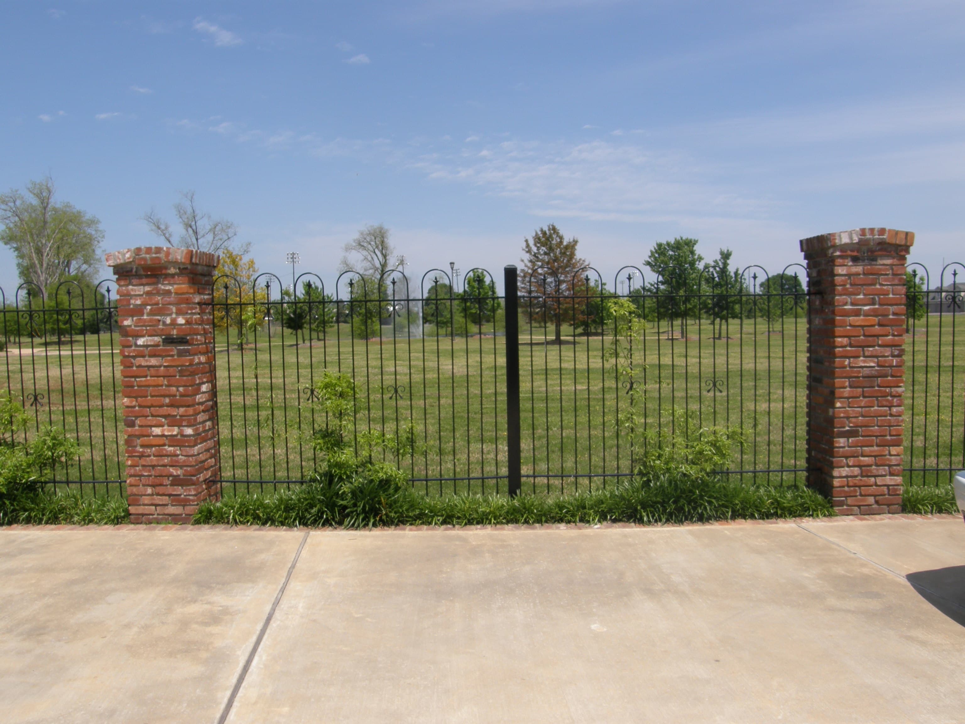 Brick columns with iron panel fence