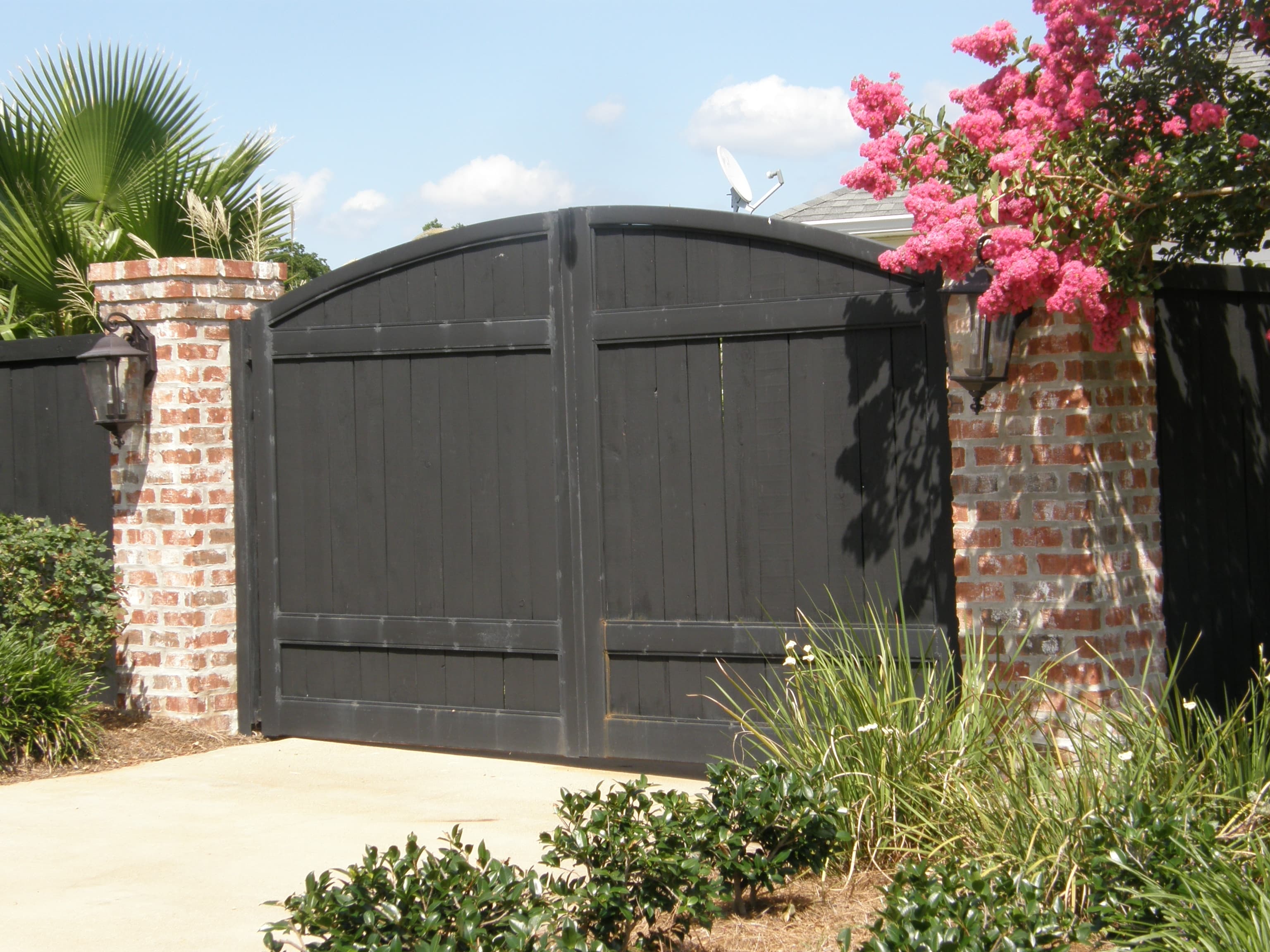 Brick column driveway gate with wood panels